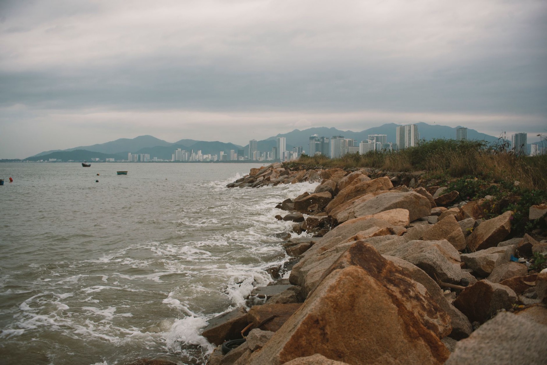 Nha Trang — Dramatic coastal cityscape featuring rocky shoreline in Nha Trang, Vietnam.