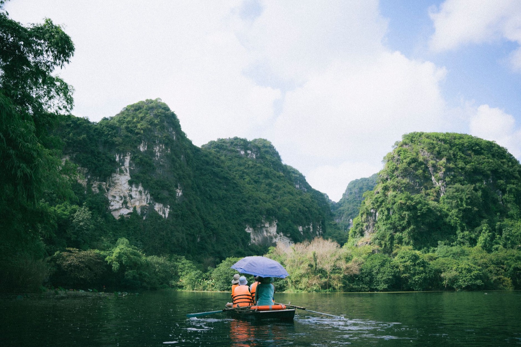 Ninh Binh — Scenic boat journey in Ninh Bình, Vietnam, surrounded by lush limestone mountain